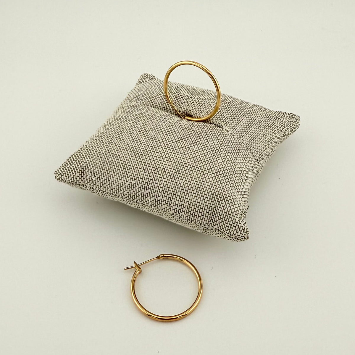 ANNA VON BERGMANN BASIS CREOLE aus 18 kt goldplattiertem Messing, Paar auf grauem Schmuckkissen