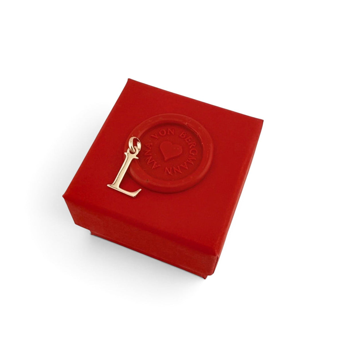 ANNA VON BERGMANN goldplattierter Buchstaben-Anhänger L auf einer roten Geschenkbox mit Marken-Siegel