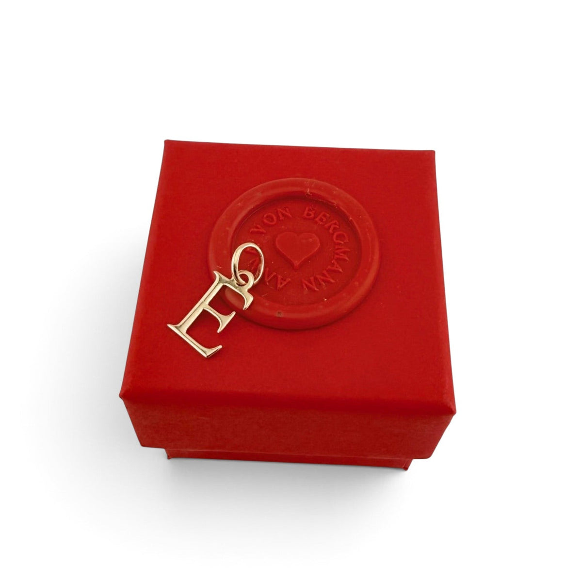 ANNA VON BERGMANN Buchstaben Anhänger E aus goldplattiertem Messing auf einer roten Geschenkbox