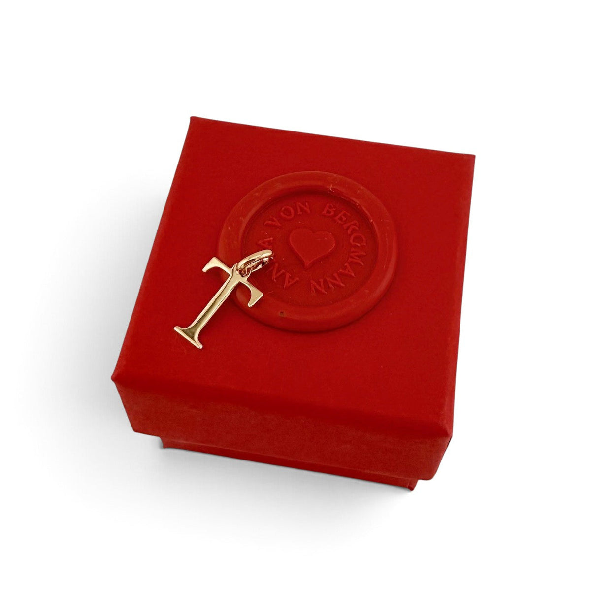 ANNA VON BERGMANN goldplattierter Buchstaben-Anhänger T auf einer roten Geschenkbox mit Siegel