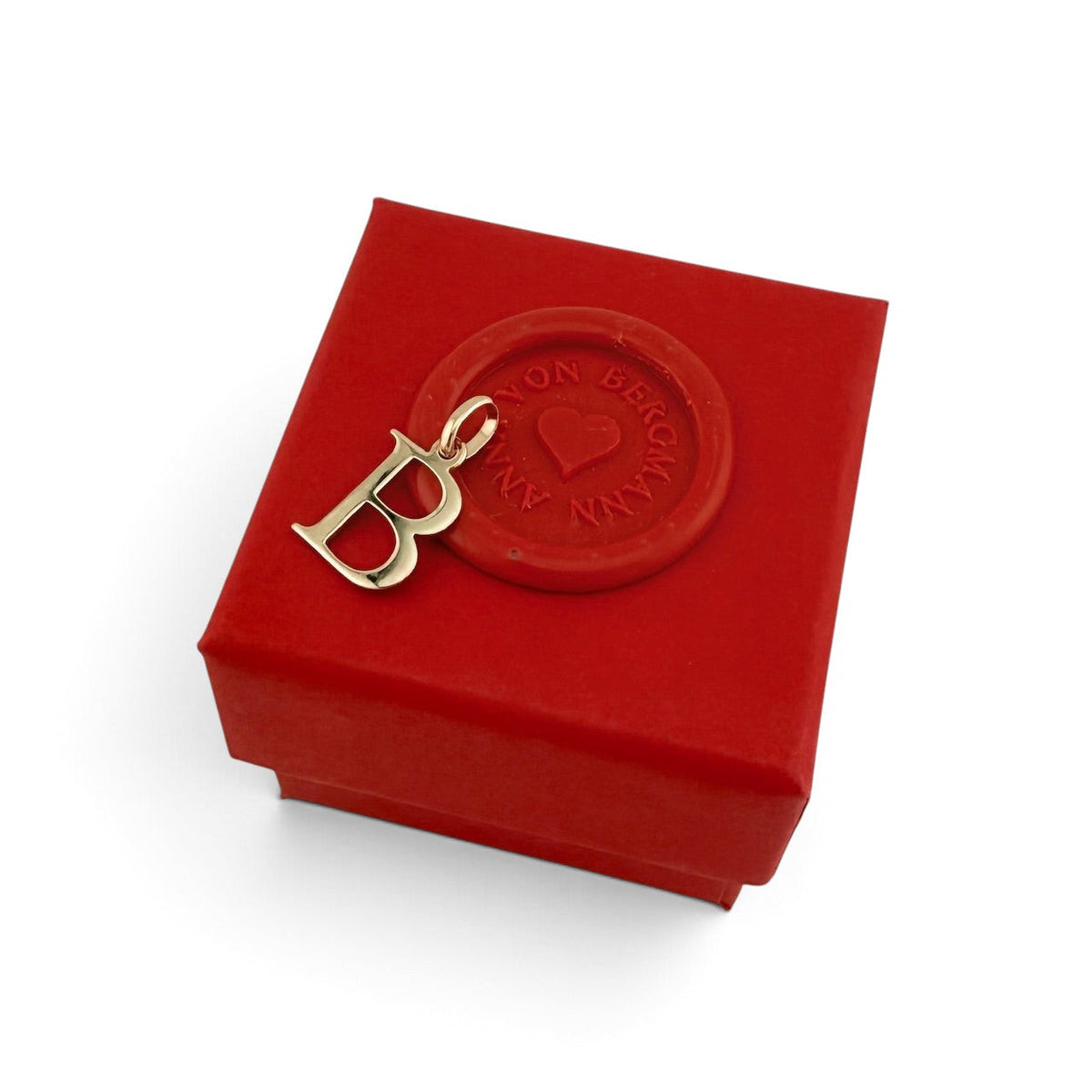 ANNA VON BERGMANN goldplattierter Buchstaben-Anhänger B auf einer roten Geschenkbox mit Siegel