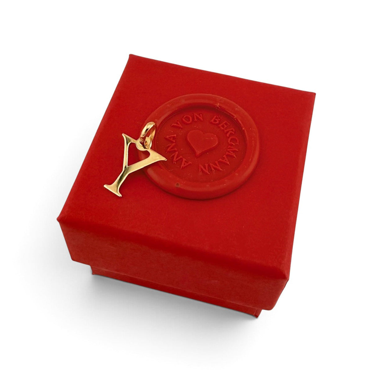 ANNA VON BERGMANN goldplattierter Buchstaben-Anhänger auf einer roten Geschenkbox mit Siegel