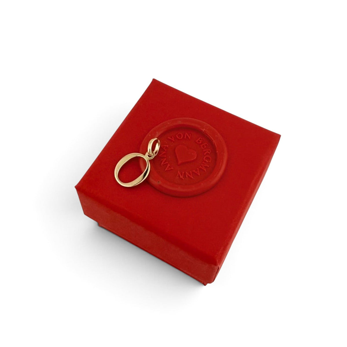 ANNA VON BERGMANN goldplattierter Buchstaben-Anhänger O auf einer roten Geschenkbox mit Siegel