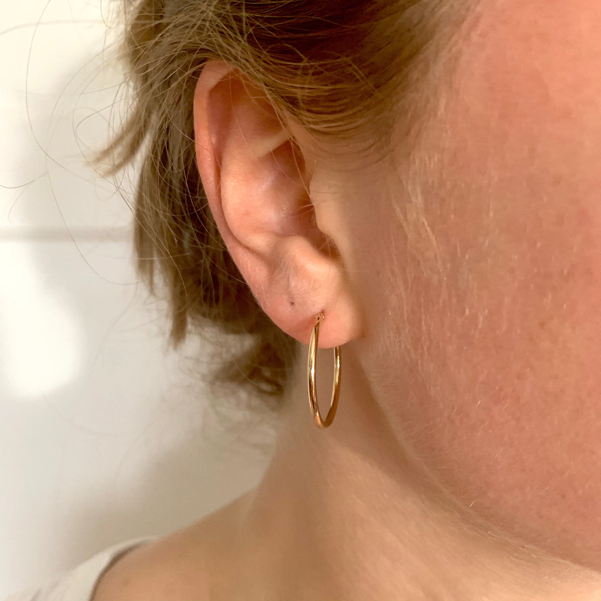 ANNA VON BERGMANN BASIS CREOLE aus 18 kt goldplattiertem Messing, getragen am Ohr