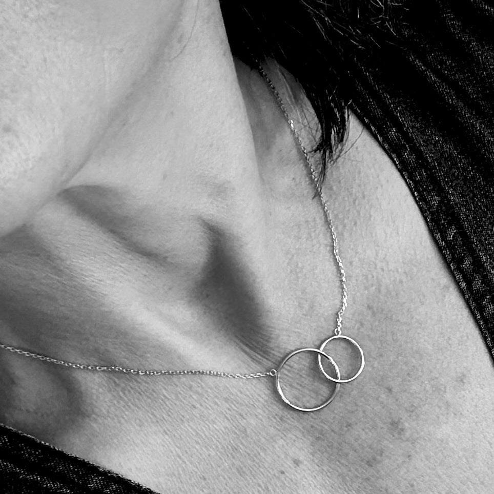 ANNA VON BERGMANN Kette DREAMCATCHER aus goldplattiertem Messing, zwei verbundene Ringe am Hals getragen, schwarz-weiß