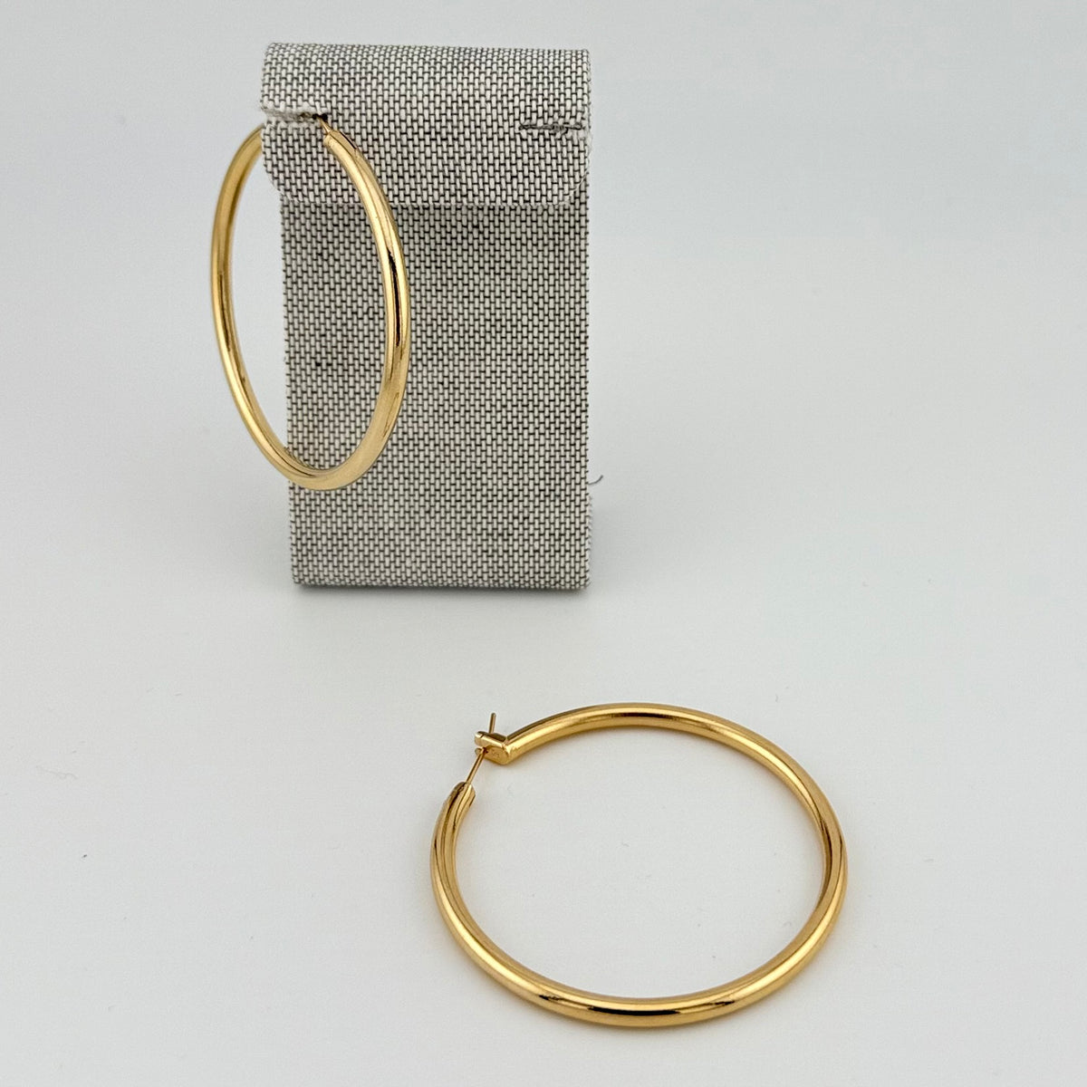 ANNA VON BERGMANN OHRCREOLEN TUBE aus 18 kt goldplattiertem Messing, große Creolen an grauem Aufsteller