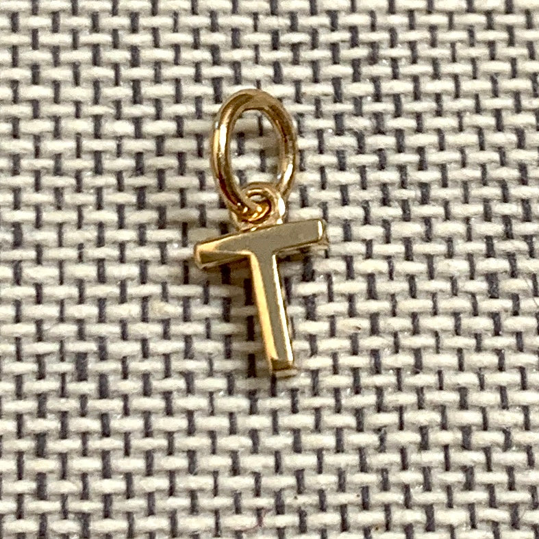 ANNA VON BERGMANN Buchstabenanhänger PETITE LETTRE aus 18 kt goldplattiertem Messing, Buchstabe T auf grauem Stoff