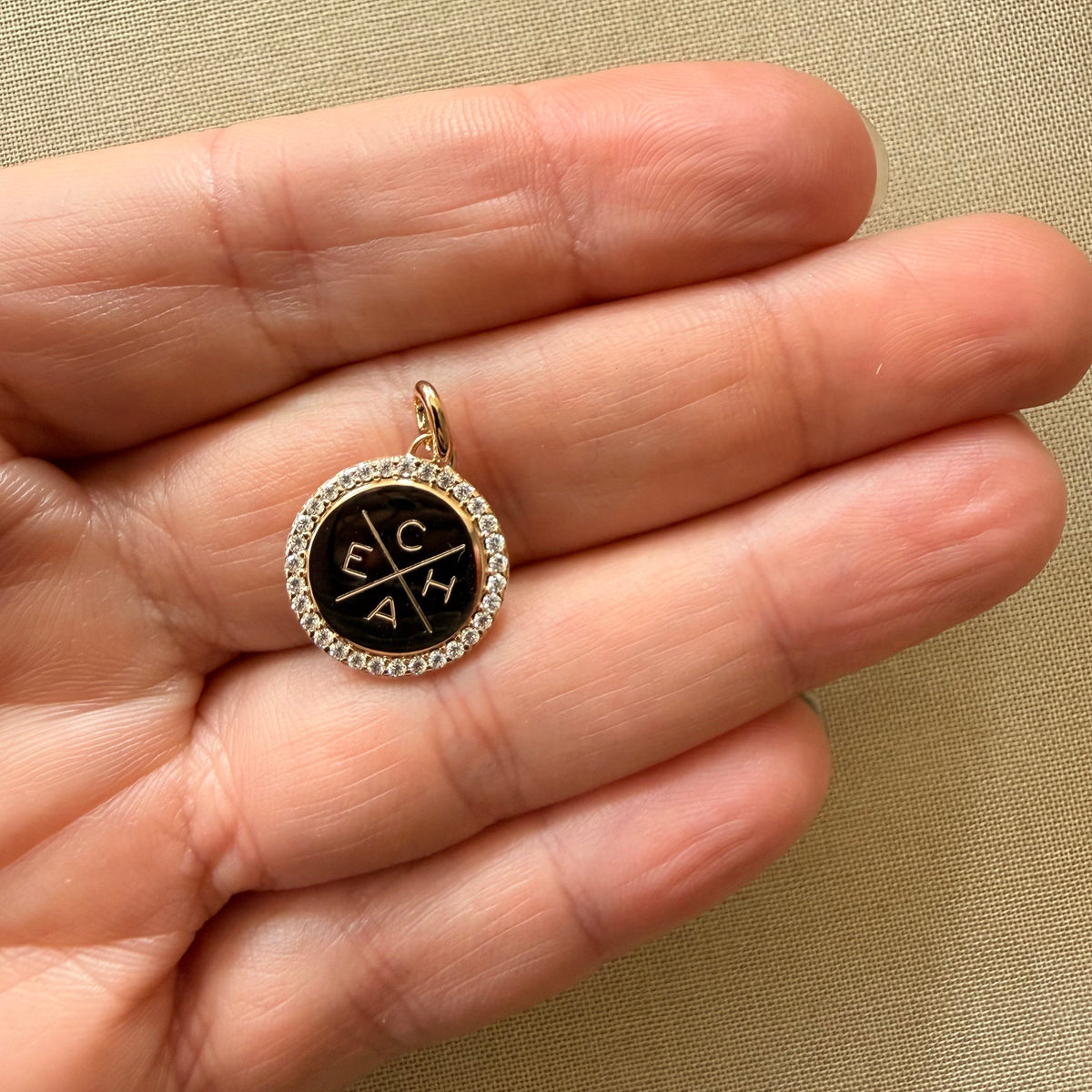 ANNA VON BERGMANN Anhänger CHERRY BLOSSOM aus 18 kt goldplattiertem Messing, schwarze Plakette mit Zirkoniarand in der Hand