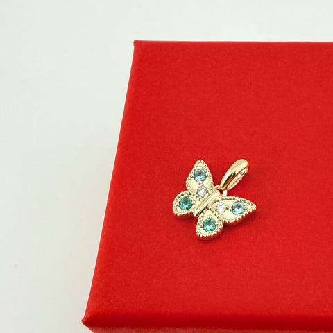 Goldener Schmetterling-Anhänger BUTTERFLY mit grünen und blauen Zirkonia aus recyceltem Edelmetall auf roter Geschenkbox – Anna von Bergmann München