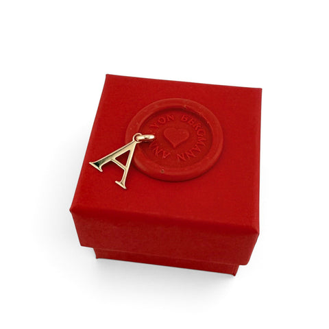 ANNA VON BERGMANN Buchstaben Anhänger A aus goldplattiertem Messing auf einer roten Geschenkbox