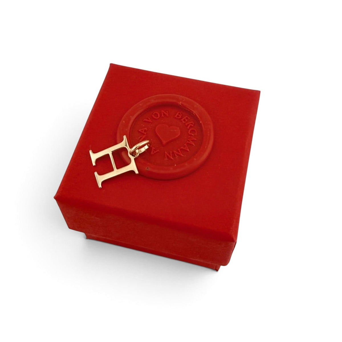 ANNA VON BERGMANN goldplattierter Buchstaben-Anhänger H auf einer roten Geschenkbox mit Siegel
