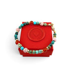 ANNA VON BERGMANN Armband Little Poem aus bunten Edelsteinen und vergoldetem Sterlingsilber auf roter Schmuckschatulle