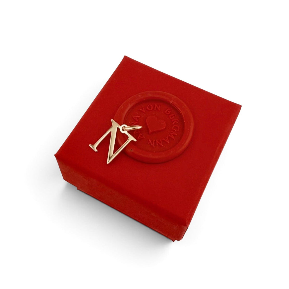 ANNA VON BERGMANN goldplattierter Buchstaben-Anhänger N auf einer roten Geschenkbox mit Siegel