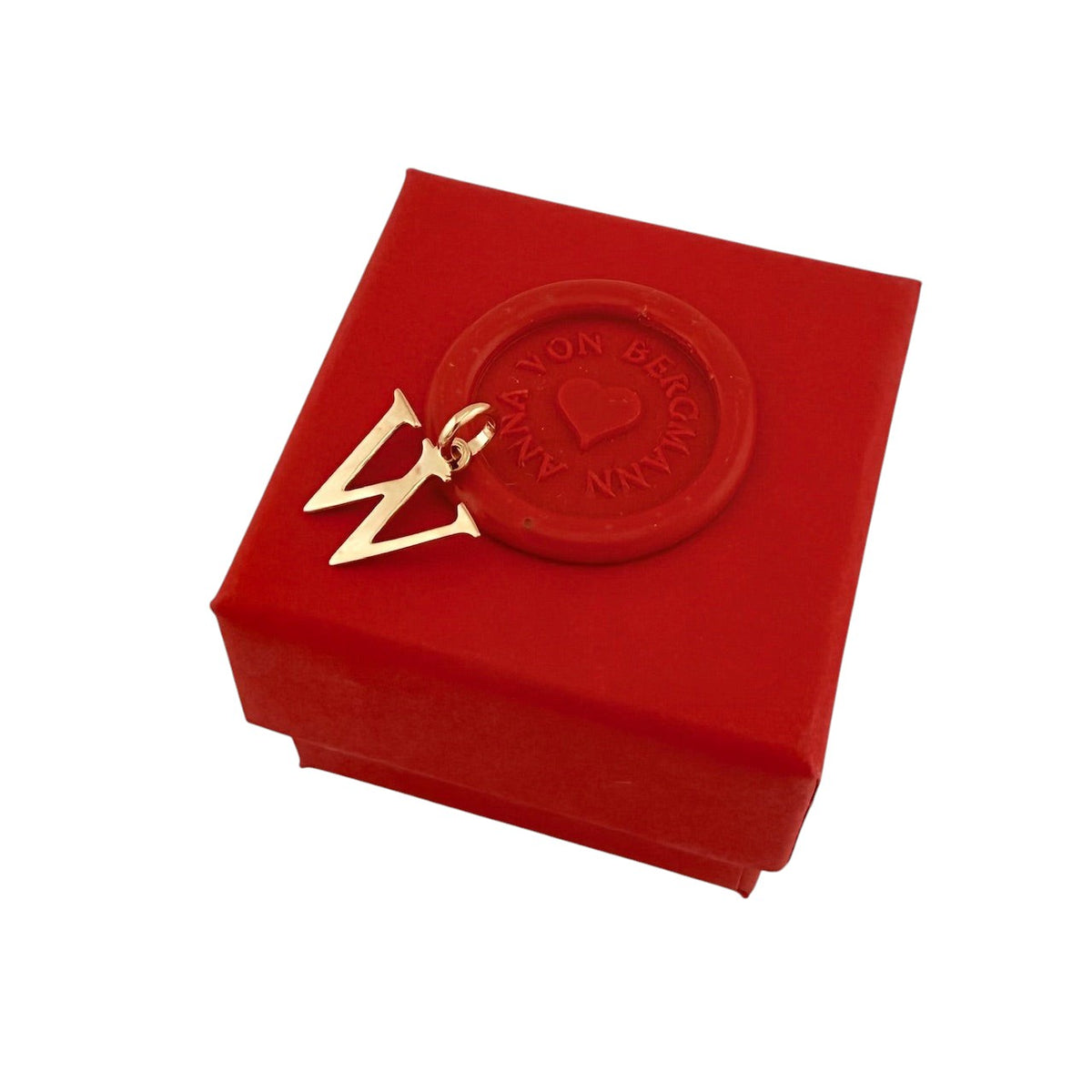 ANNA VON BERGMANN goldplattierter Buchstaben-Anhänger W auf einer roten Geschenkbox mit Siegel