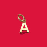 ANNA VON BERGMANN goldplattierter Buchstabenanhänger Petite Lettre in Form eines A auf rotem Hintergrund