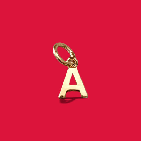 ANNA VON BERGMANN goldplattierter Buchstabenanhänger Petite Lettre in Form eines A auf rotem Hintergrund
