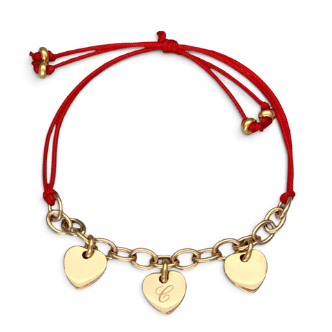 ANNA VON BERGMANN Armband mit drei gravierbaren goldenen Herzanhängern an rotem Nylonband