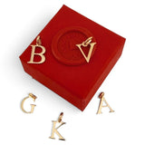 ANNA VON BERGMANN goldplattierte Buchstaben-Anhänger aus Messing auf einer roten Schmuckschatulle