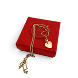 ANNA VON BERGMANN Kette mit herzförmigem Anhänger aus goldplattiertem Messing auf einer roten Geschenkbox