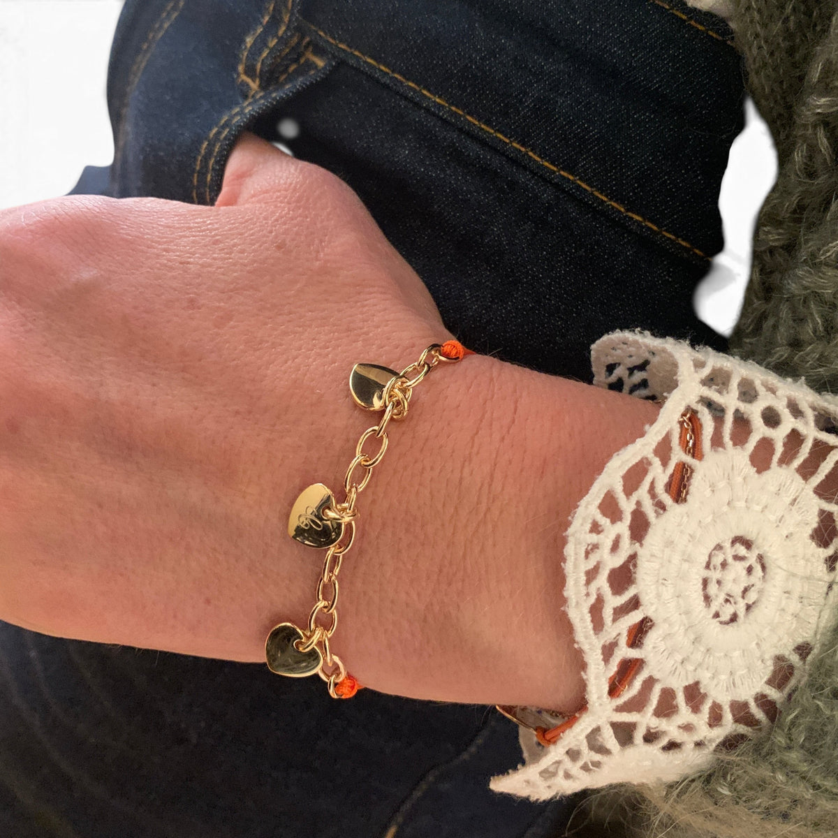ANNA VON BERGMANN Armband mit drei gravierbaren Herzanhängern aus goldplattiertem Messing an einer Nylonkordel