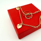Personalisierte Gravurkette Family Mini mit goldenen Herzanhängern aus recyceltem Edelmetall auf roter Geschenkbox – Anna von Bergmann München