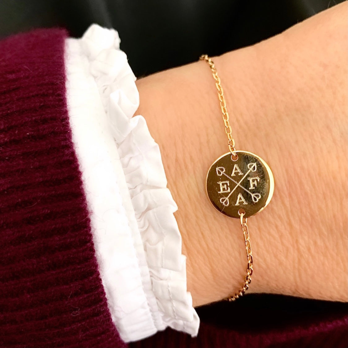 ANNA VON BERGMANN Armband DAISY mit Gravur aus goldplattiertem Messing getragen am Handgelenk, Buchstaben und Pfeile