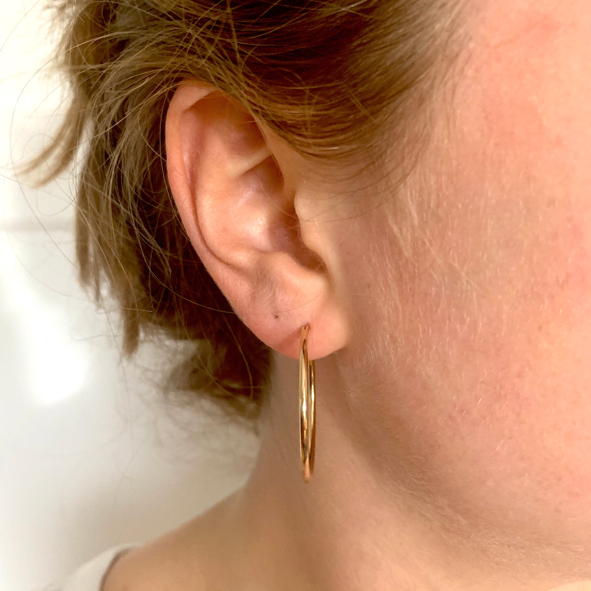 ANNA VON BERGMANN BASIS CREOLE aus 18 kt goldplattiertem Messing, getragen am Ohr